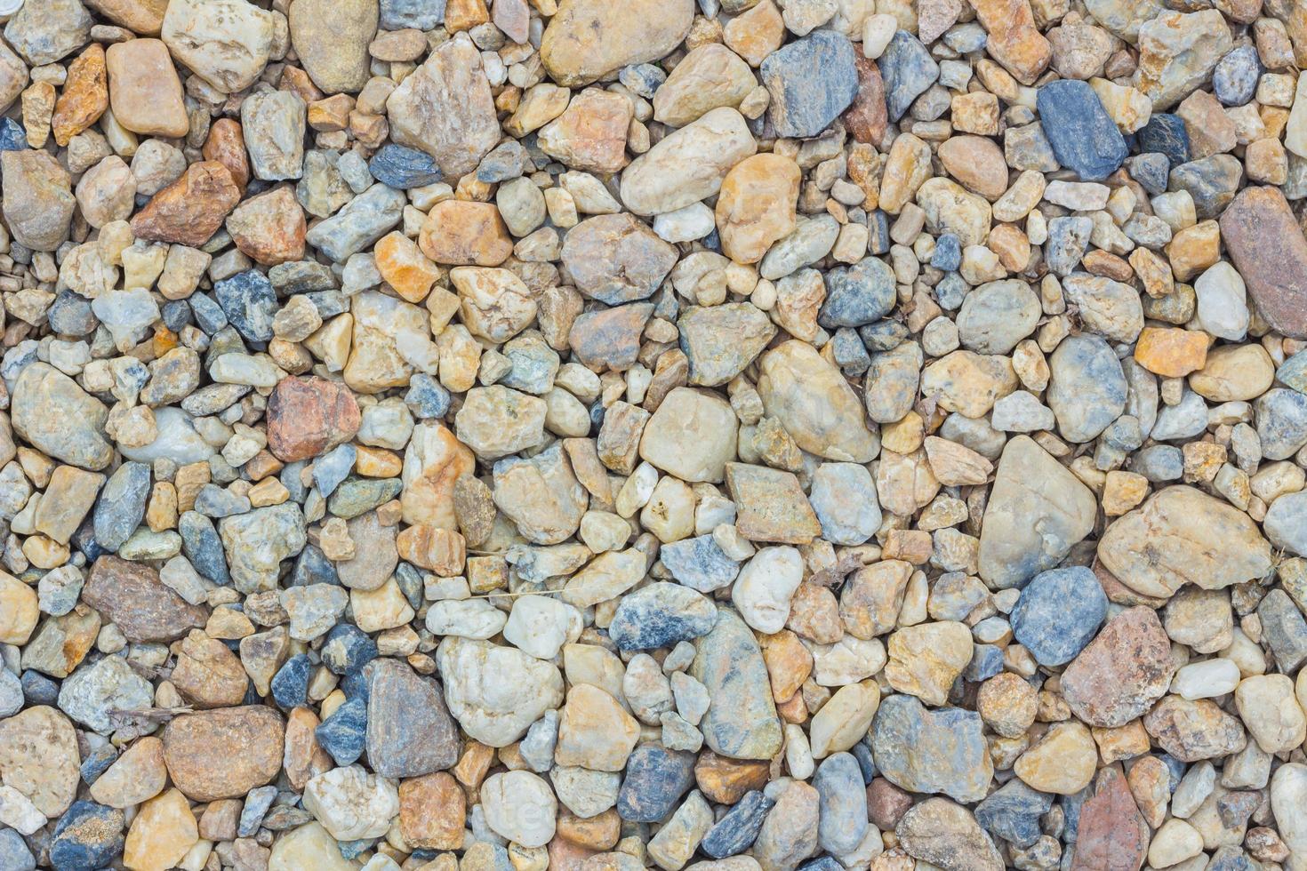 Textura de piedras de cantos rodados de colores en el suelo foto