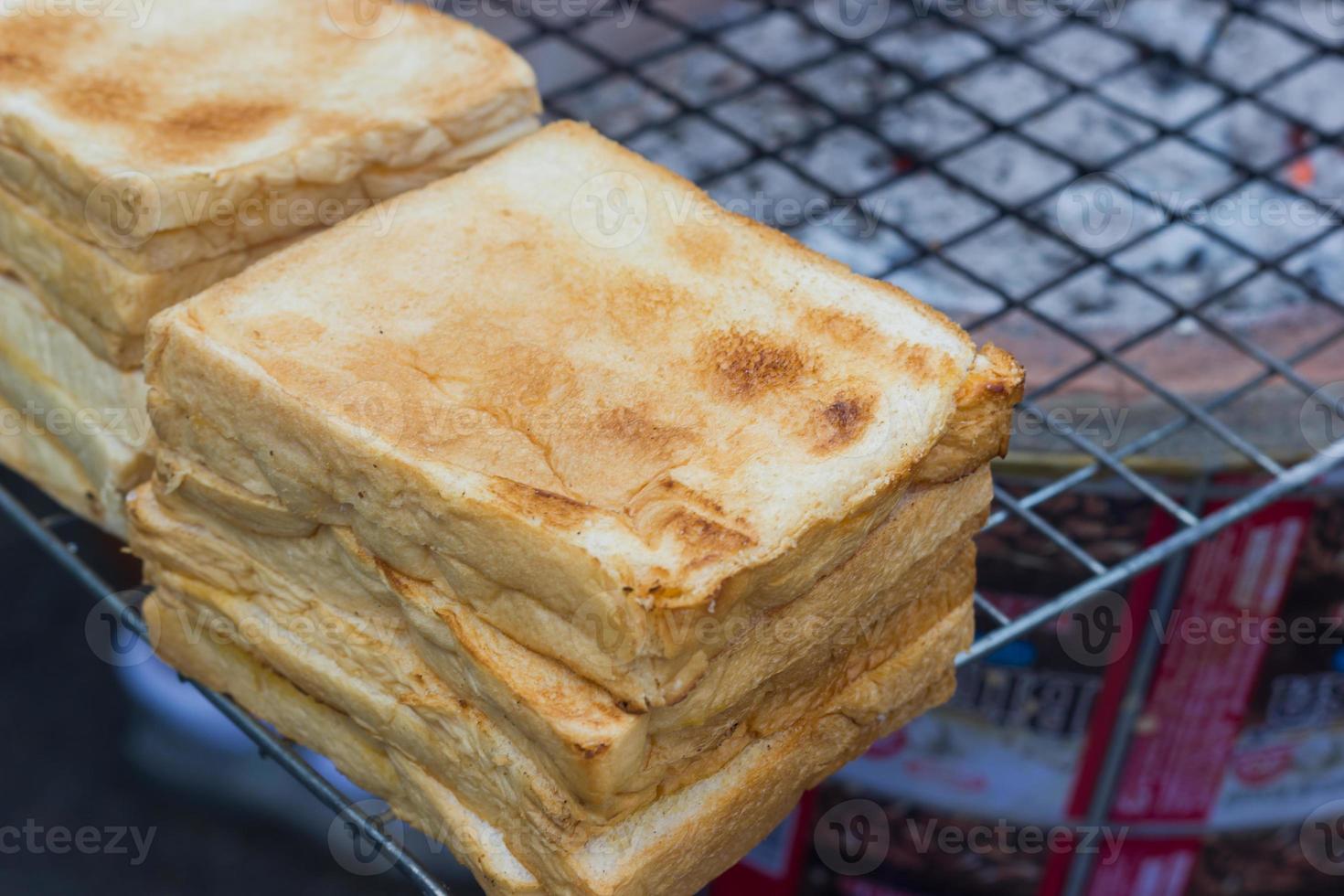 Primer plano tostadas de pan a la parrilla en la estufa tradicional tailandesa. foto