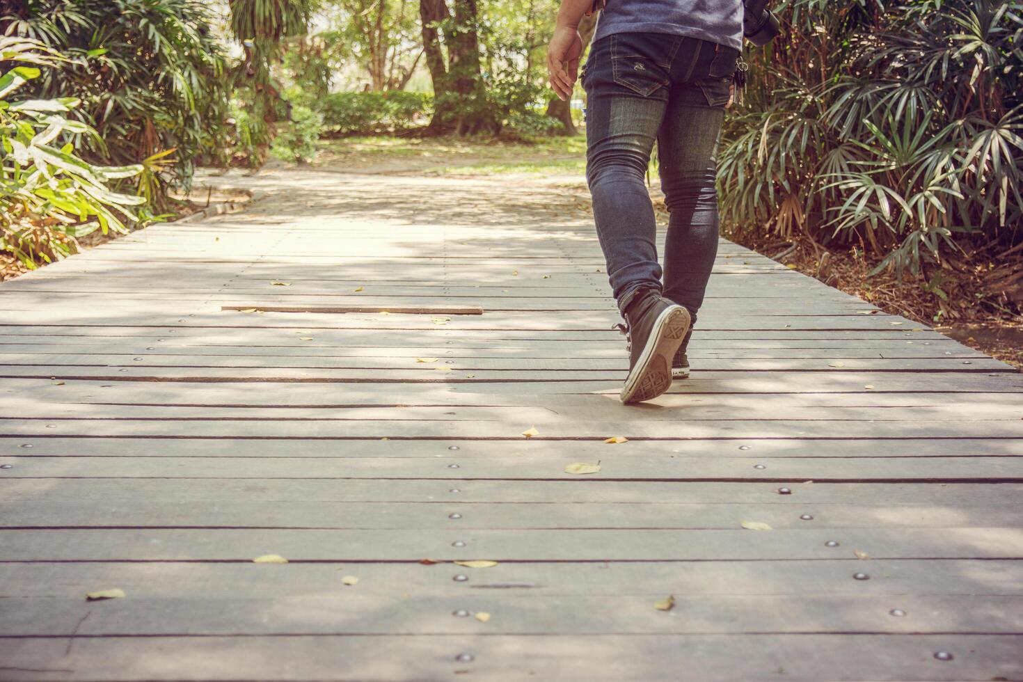 pies de hombre va en zapatillas de deporte caminando en el parque foto