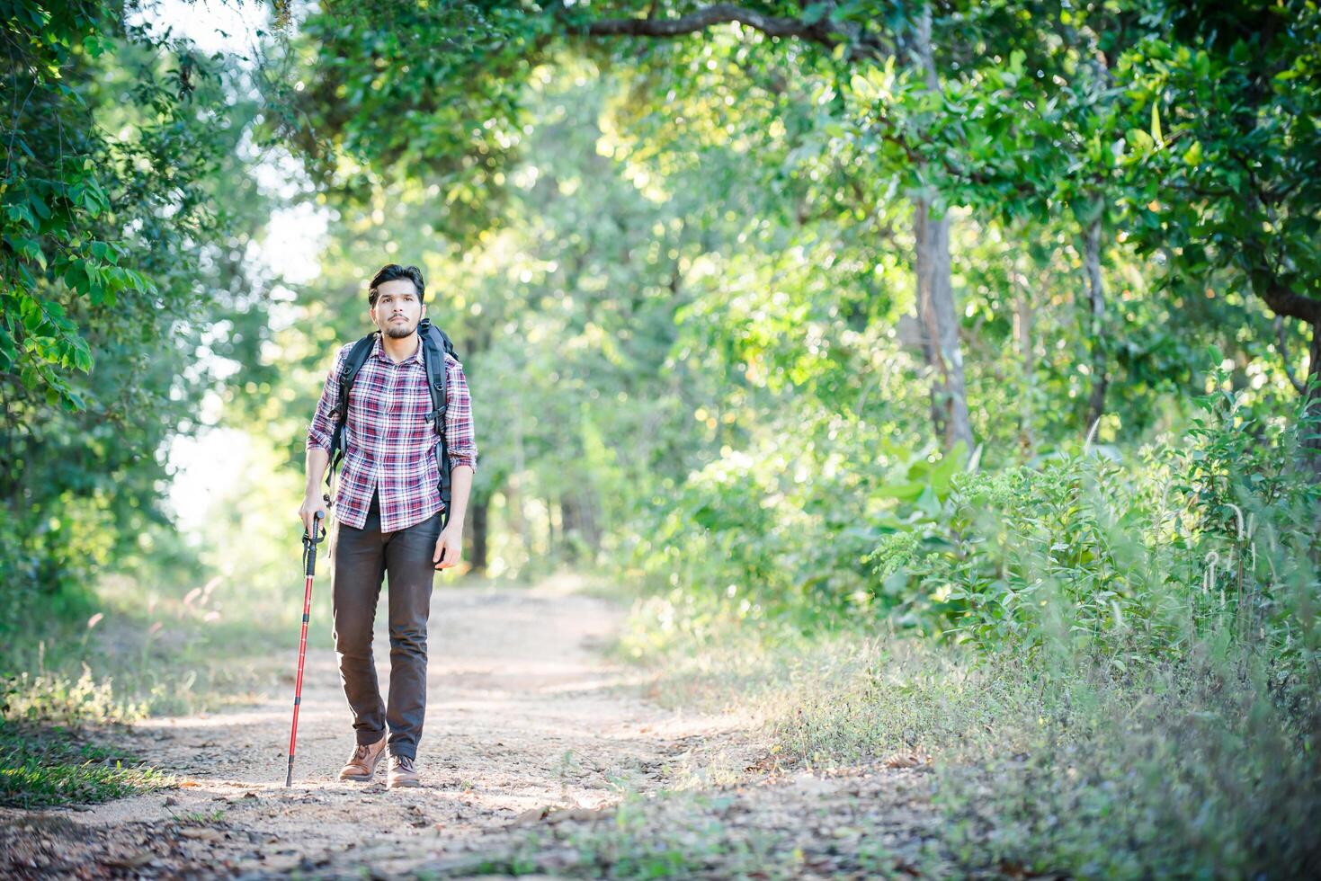 Young hipster man walking on the rural road during hikes on vacation. photo