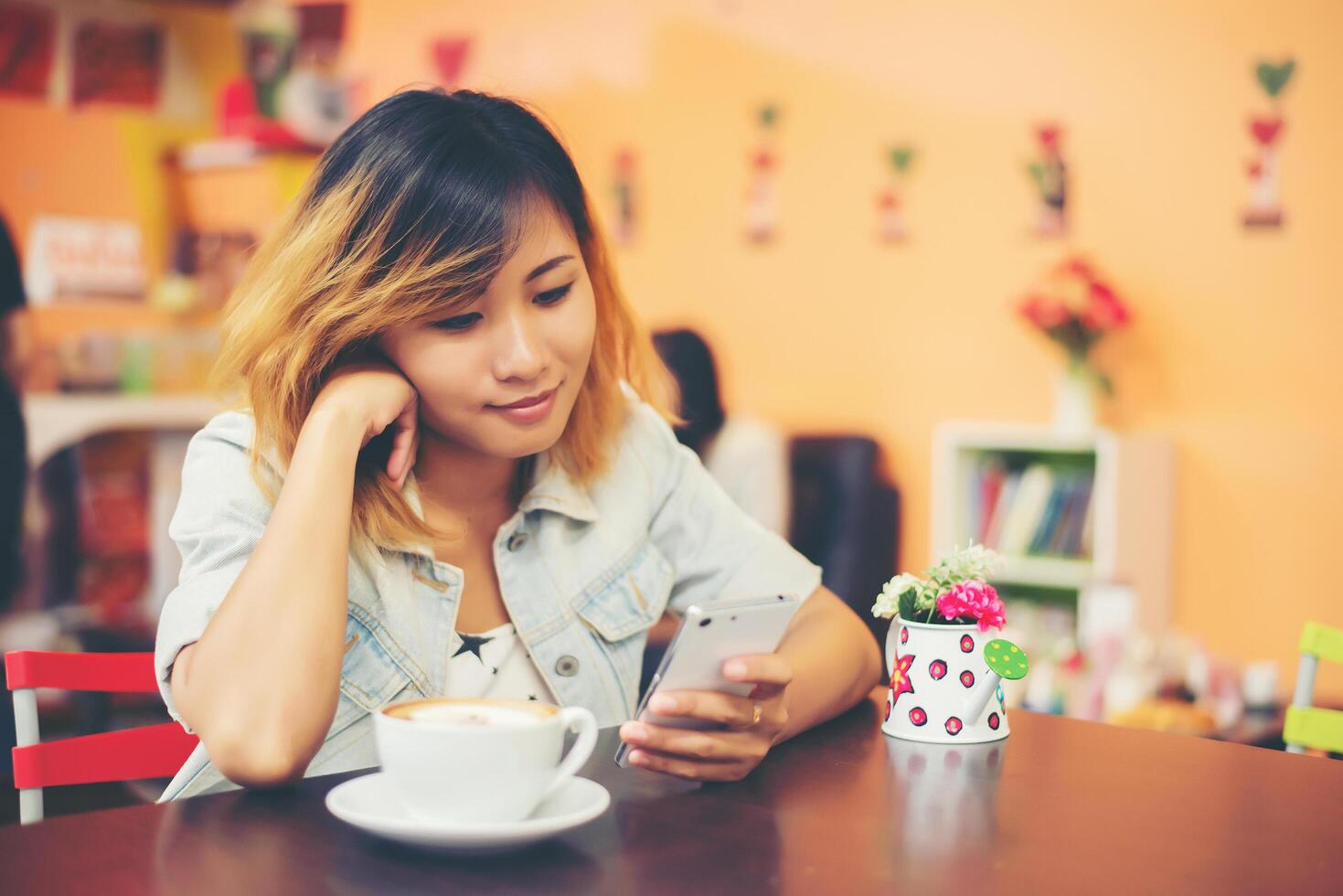 primer plano de mensajes de texto de mujer con su móvil en la cafetería. foto