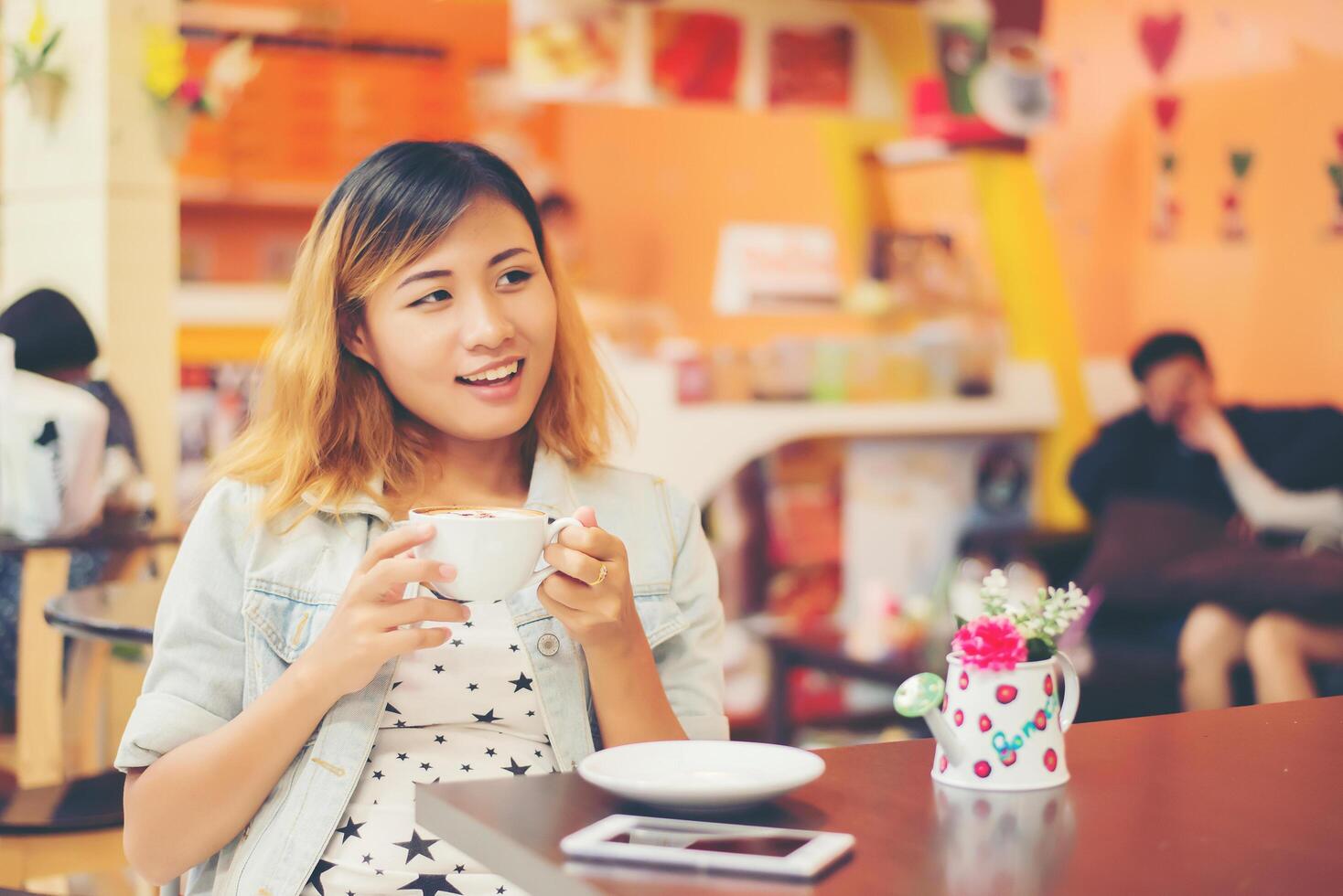 joven y bella mujer sentada en un café con café caliente. foto