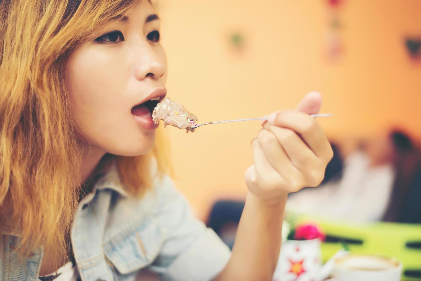 hermosas mujeres jóvenes disfrutan comiendo con helado sundae. foto