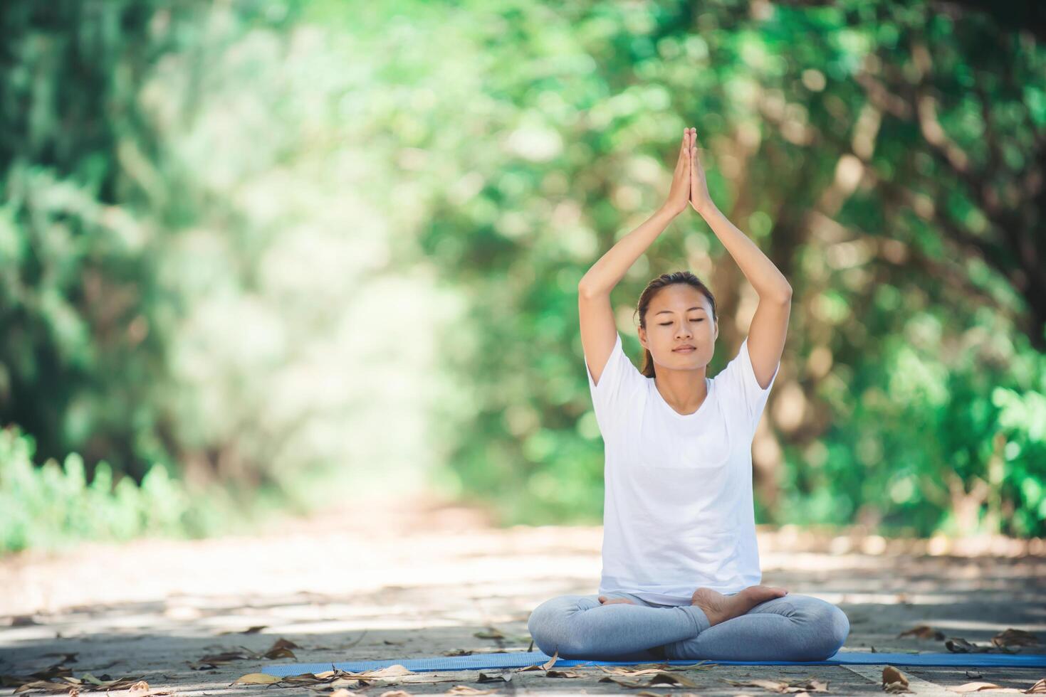 joven asiática haciendo yoga por la mañana en el parque. saludable foto