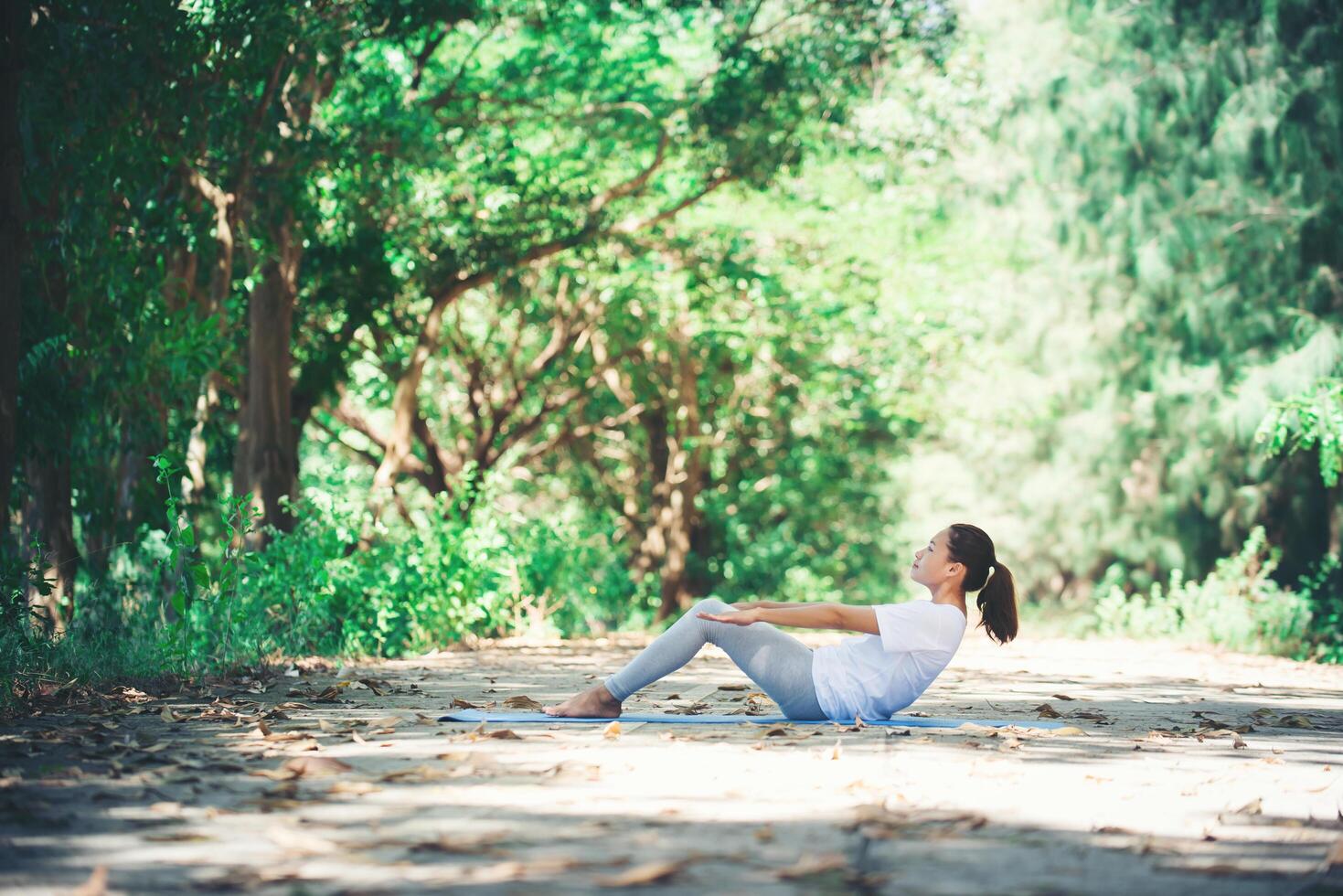 joven asiática haciendo yoga por la mañana en el parque. saludable foto