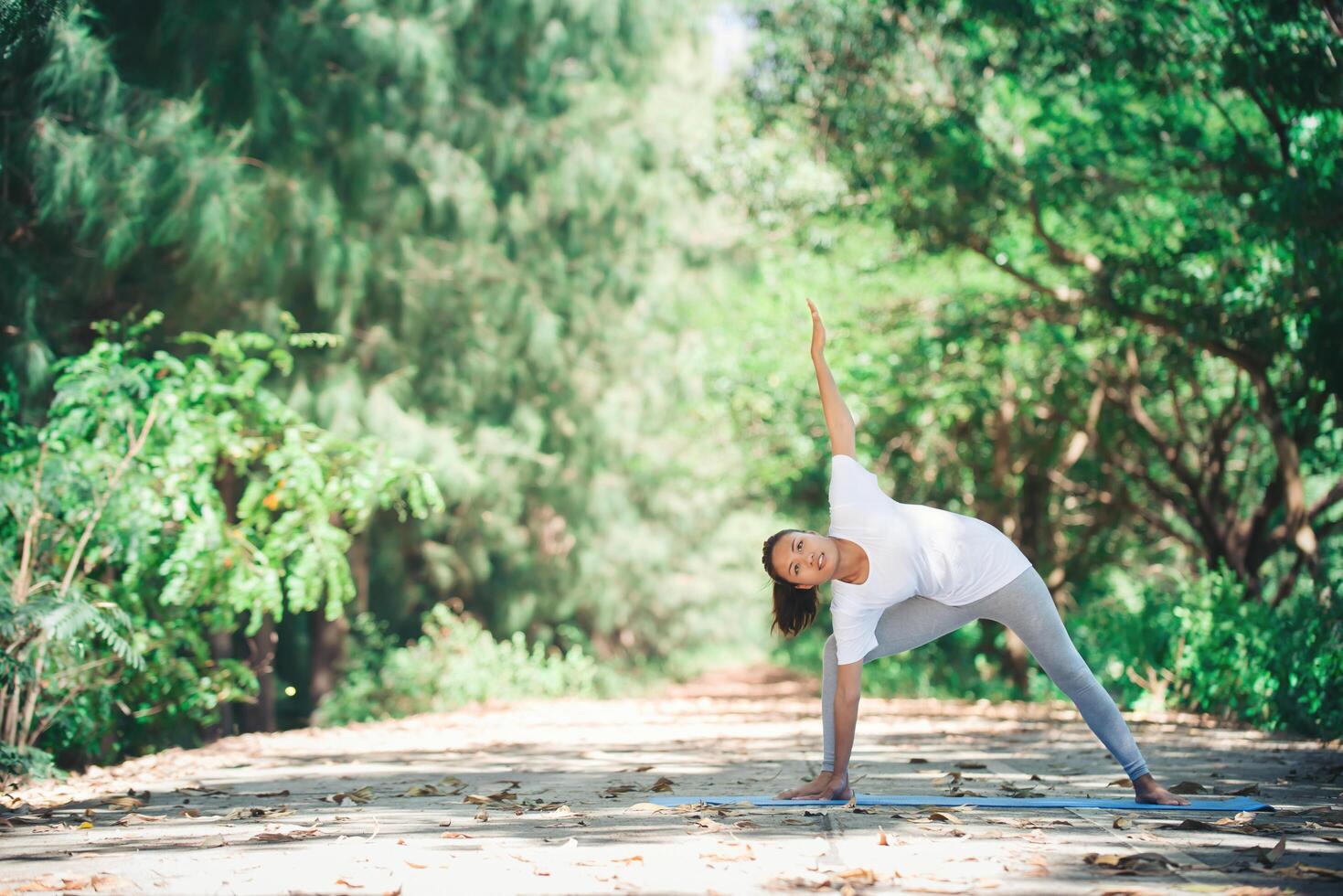 Young asian woman doing yoga in the morning at the park. Healthy photo