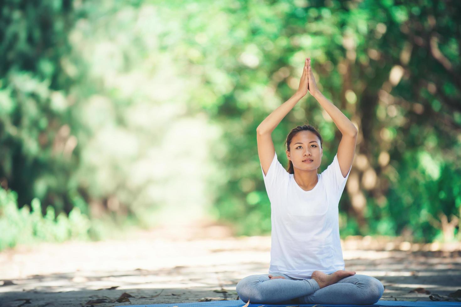 joven asiática haciendo yoga por la mañana en el parque. saludable foto