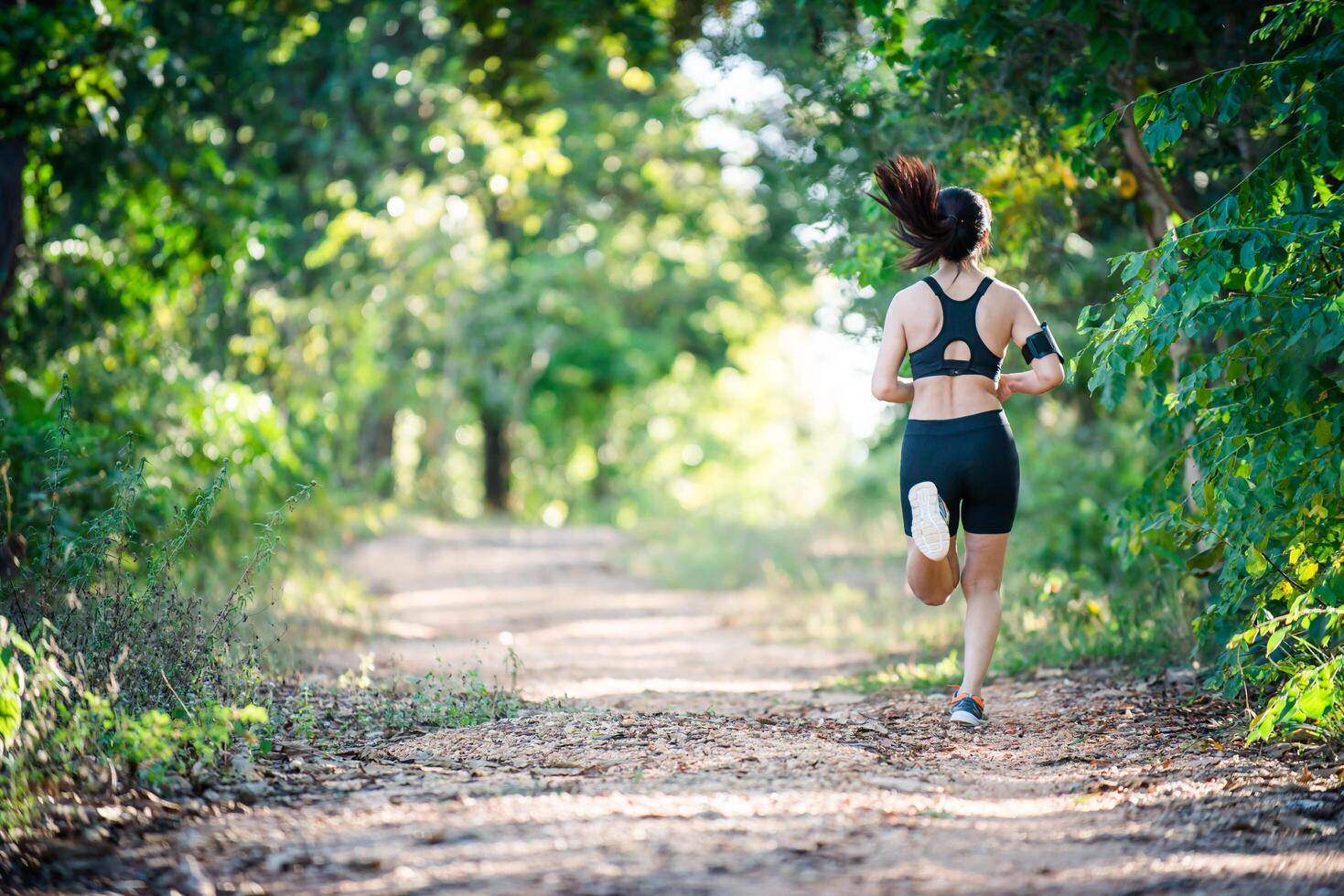 Young fitness woman running on a rural road. Sport woman running. photo