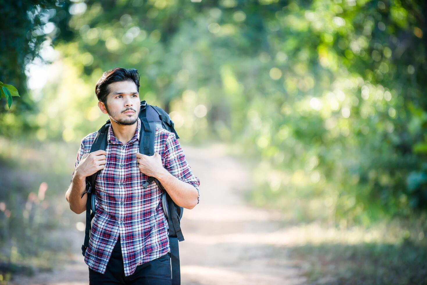 Young hipster man walking on the rural road during hikes on vacation. photo