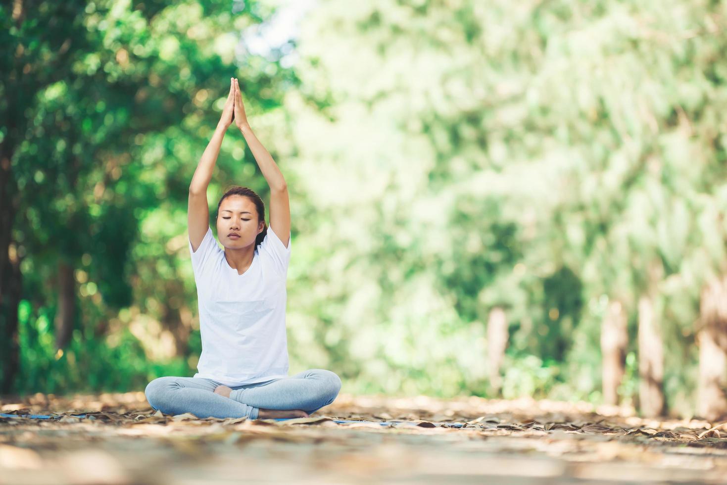 Young asian woman doing yoga in the morning at the park. Healthy photo