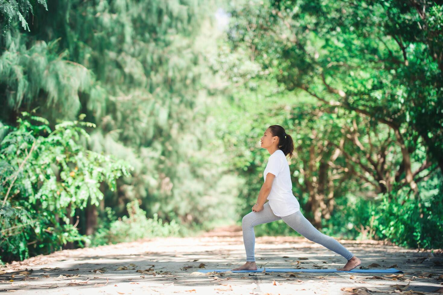 joven asiática haciendo yoga por la mañana en el parque. saludable foto