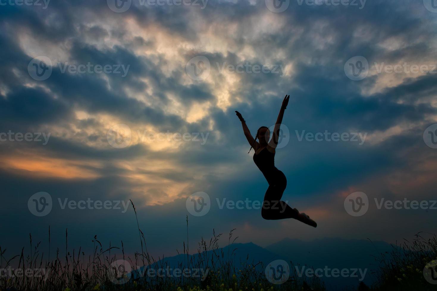 Jump in the mountains at dusk Girl in silhouette photo