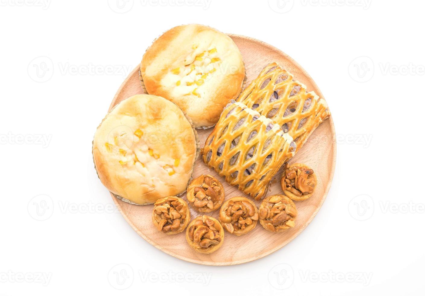 Toffee cake, bread with corn mayonaise, and taro pies on white background photo