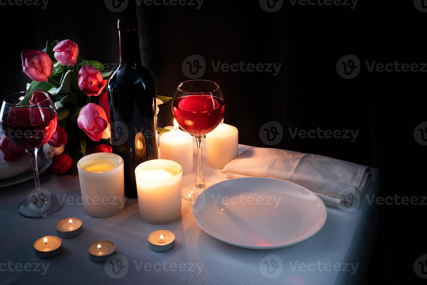Cena romántica a la luz de las velas para dos amantes, fondo oscuro. foto