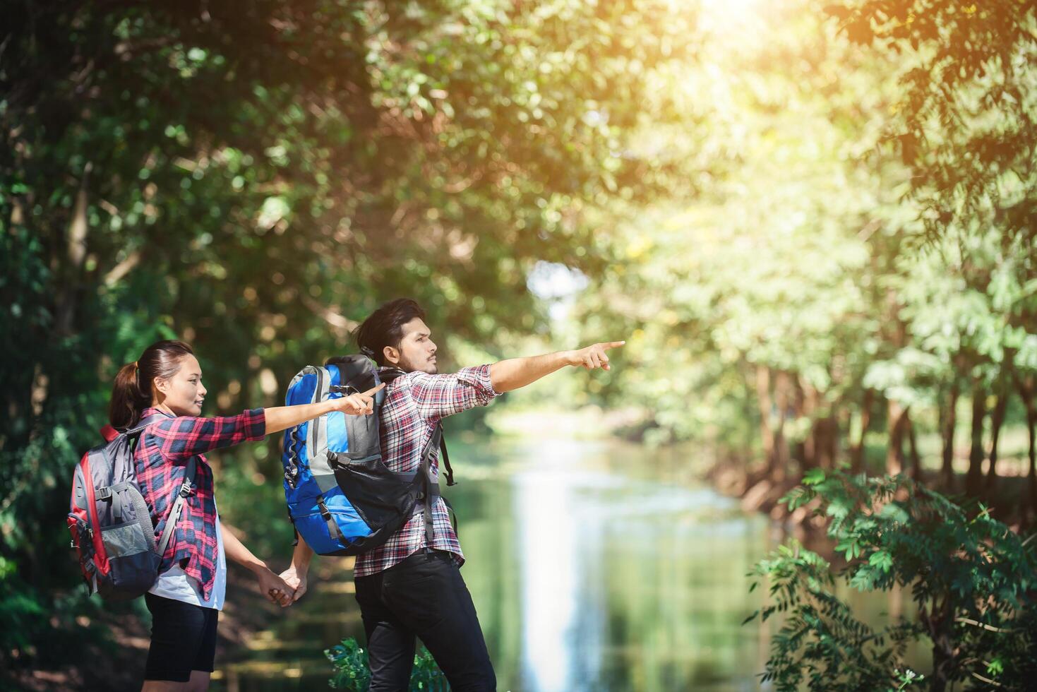 Hiking couple in forest together. Adventure travel vacation. photo