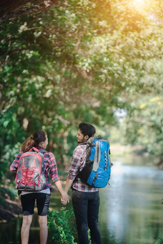 Hiking couple in forest together. Adventure travel vacation. photo