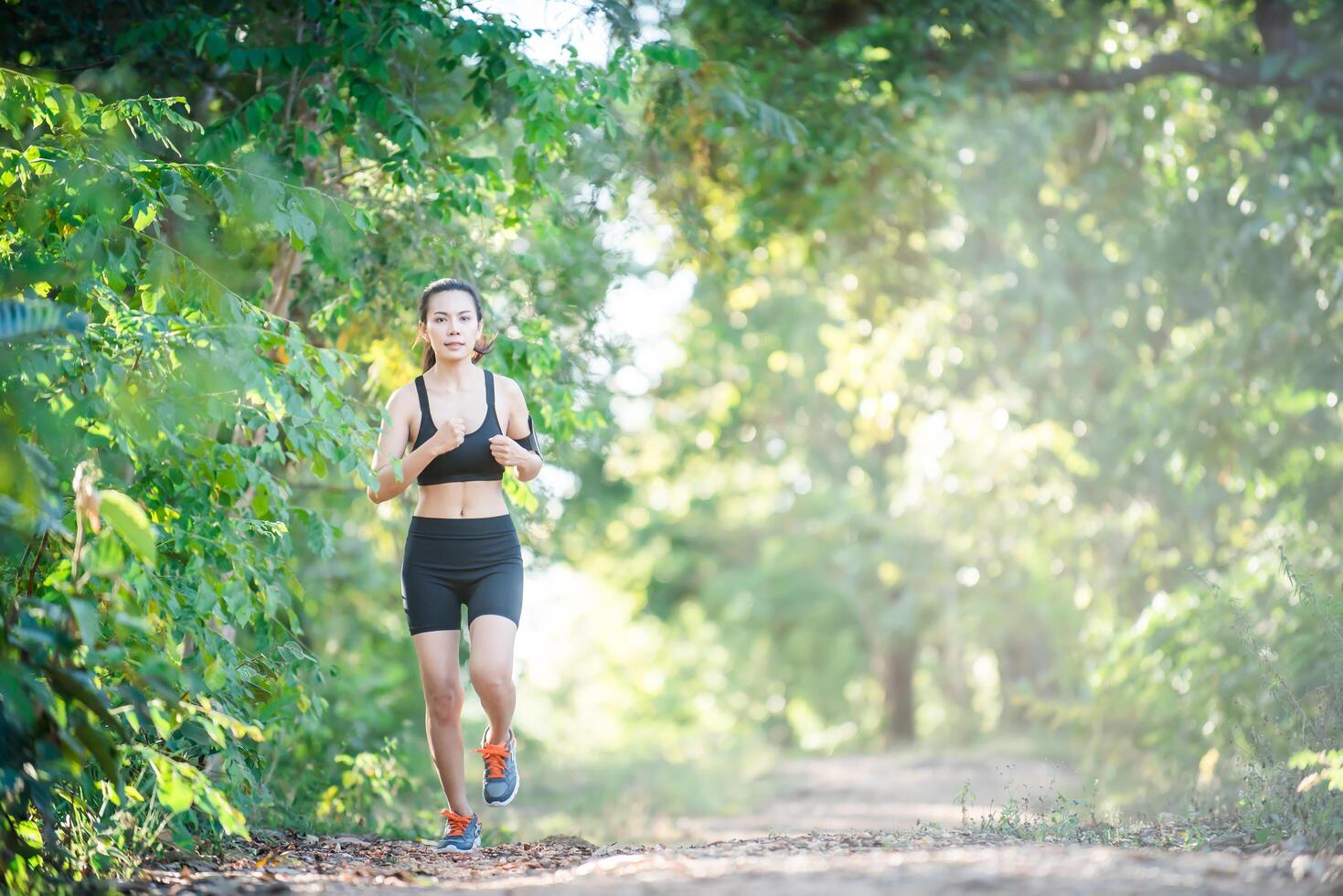 mujer joven fitness corriendo en un camino rural. mujer deportiva corriendo. foto