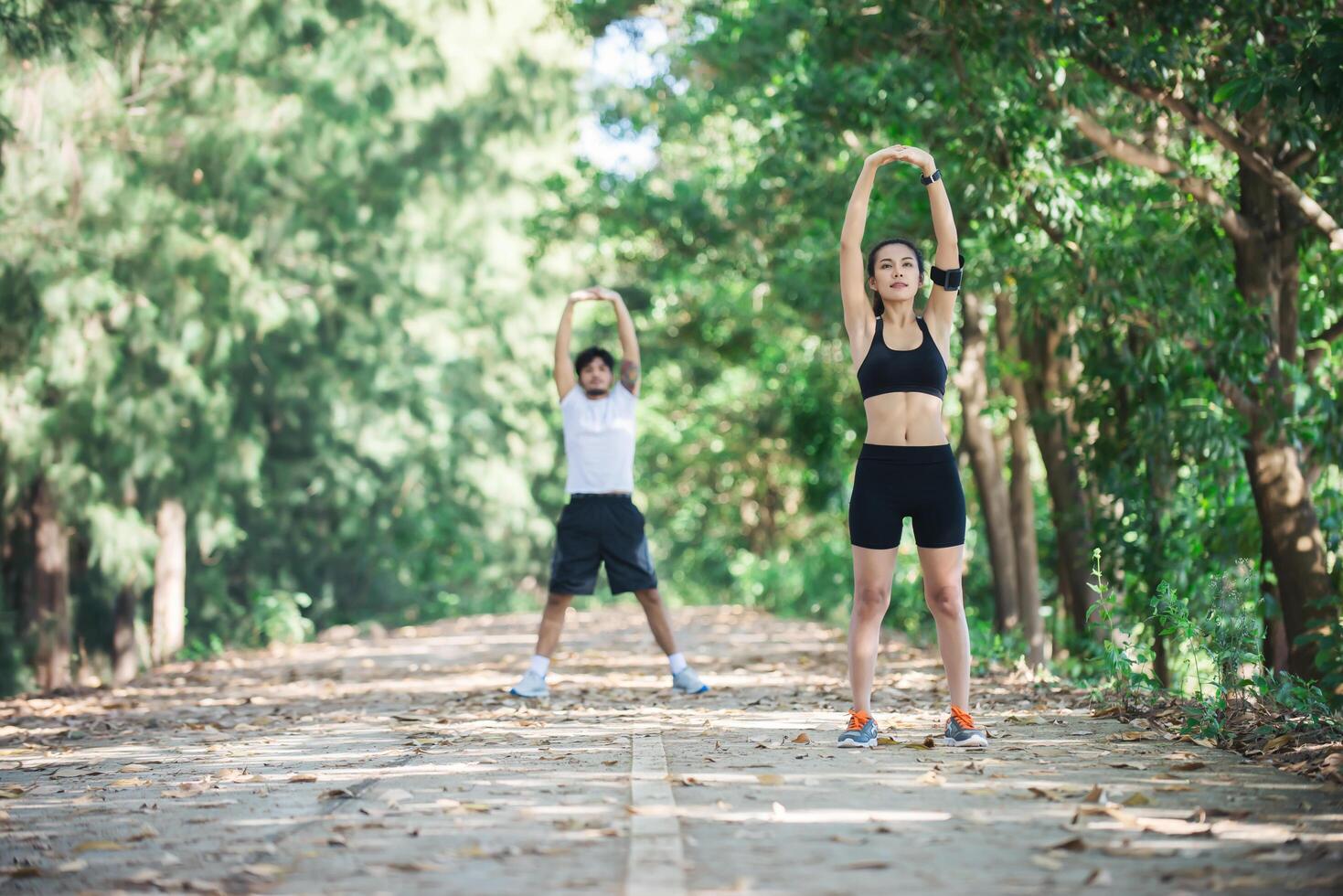 Man and woman stretching together at the park. photo