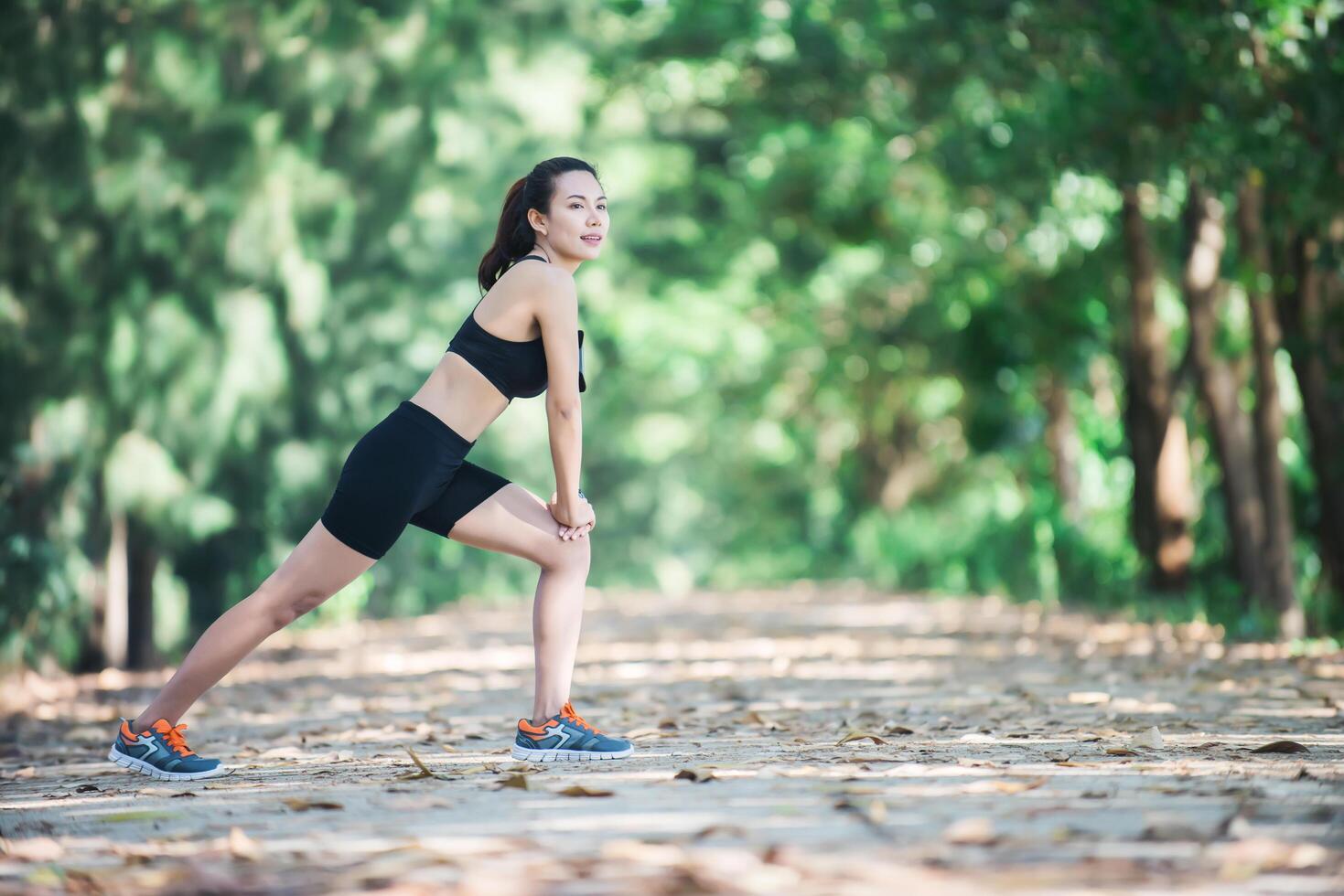 mujer joven fitness estirando las piernas antes de correr. foto