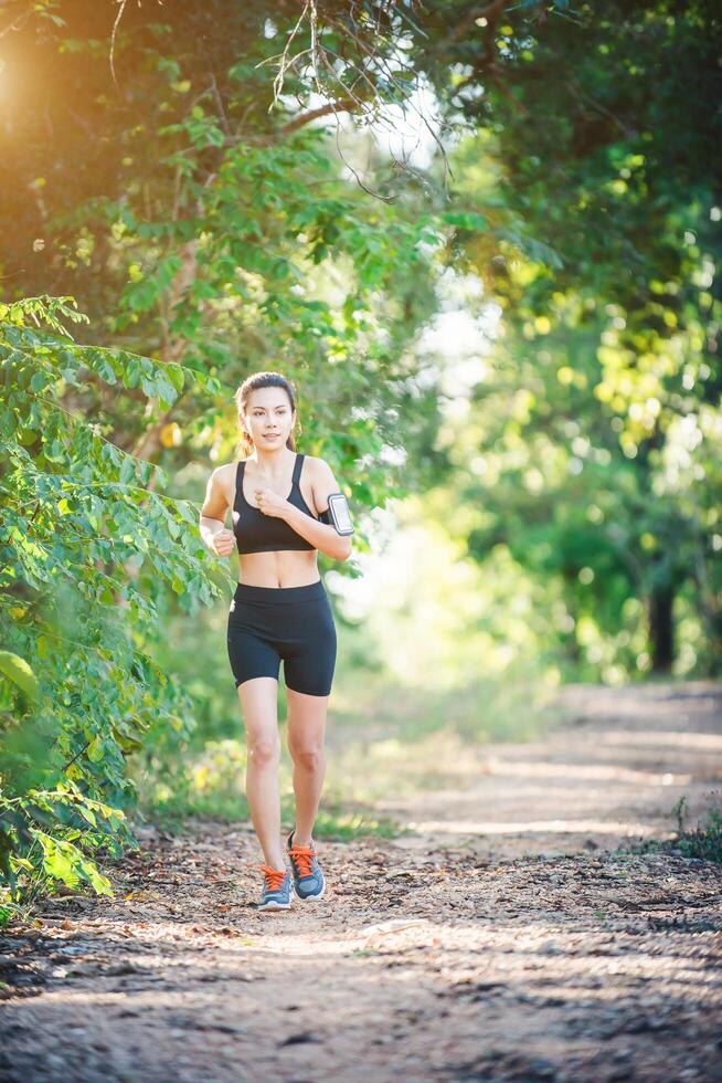 mujer joven fitness corriendo en un camino rural. mujer deportiva corriendo. foto