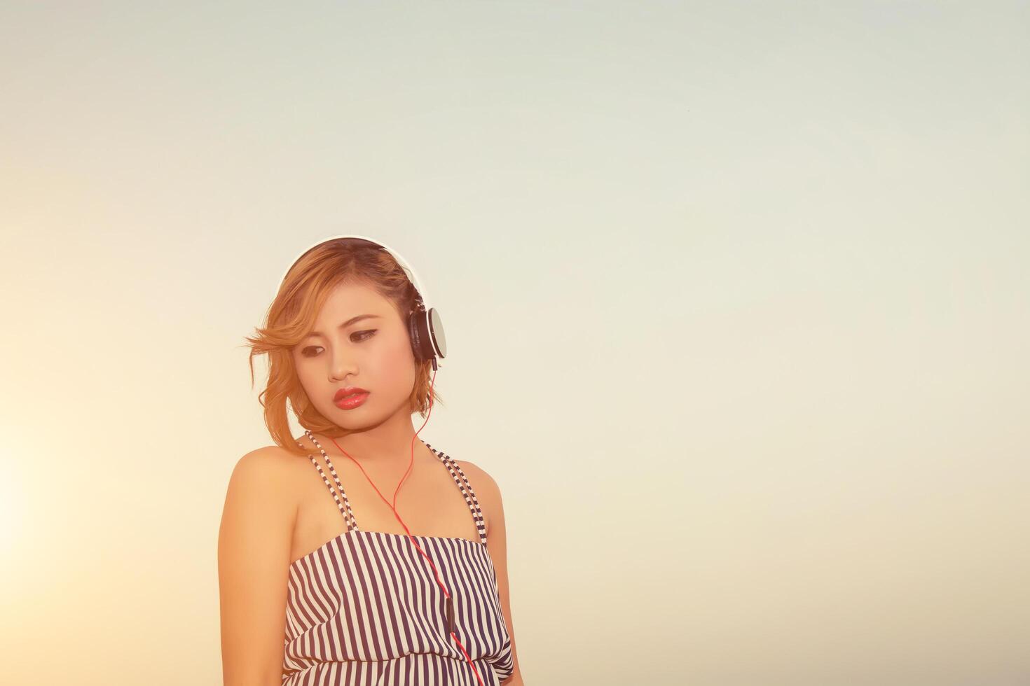 Sexy beautiful woman listening sad music from smartphone photo
