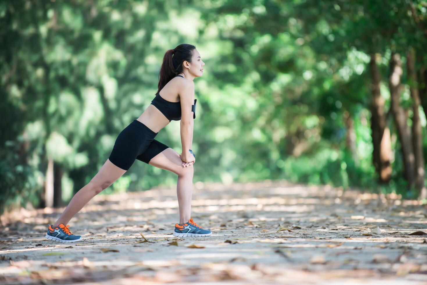 mujer joven fitness estirando las piernas antes de correr. foto