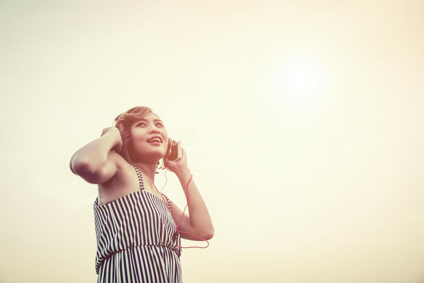 Relaxed sexy woman breathing and listening music from a smartphone photo