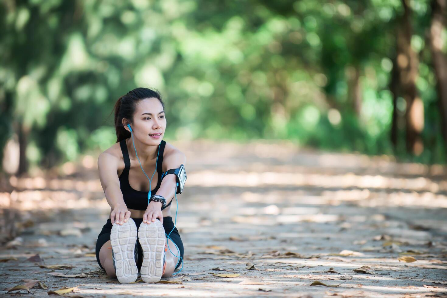 Young fitness woman stretching legs before run. photo