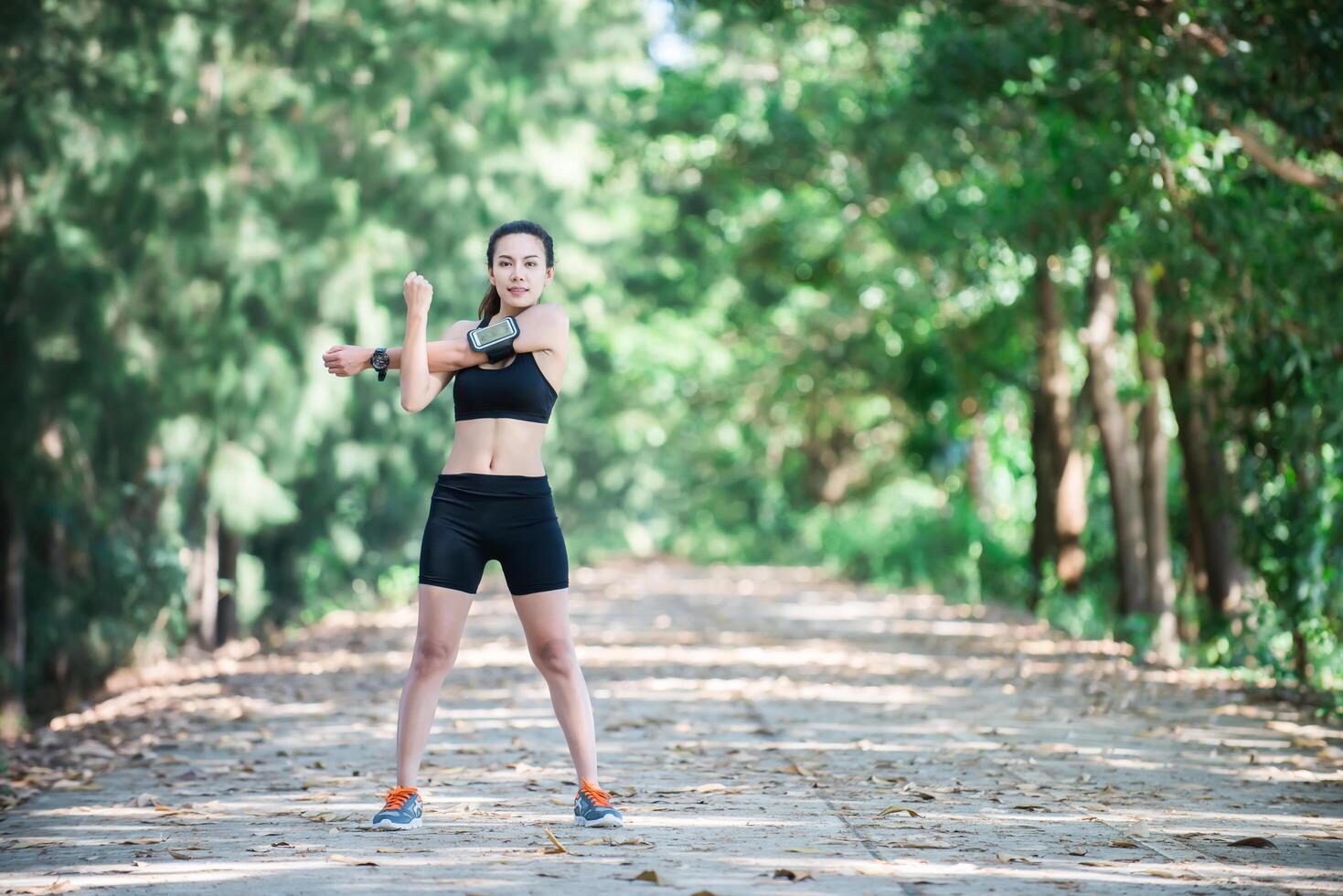 Young fitness woman stretching legs before run. photo