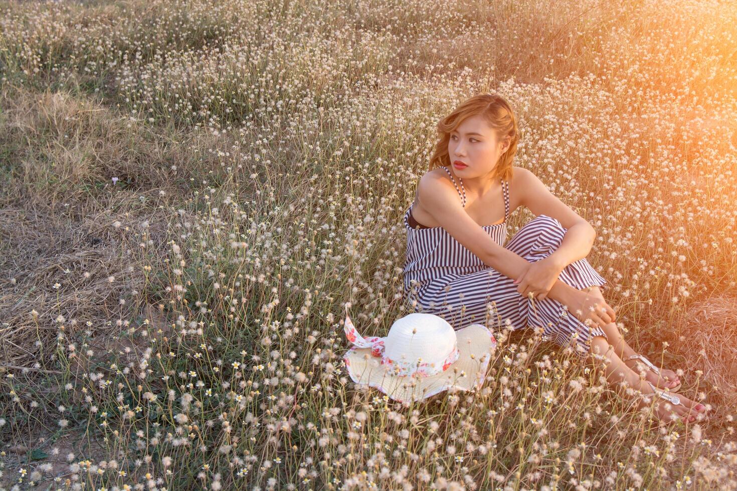 Sexy Beautiful woman sitting in flower field sadly and loneliness photo