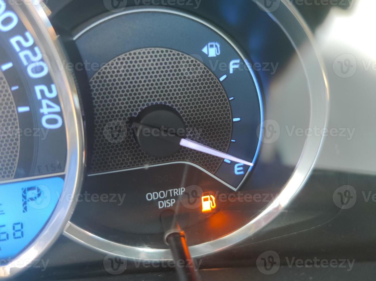 Fuel gauge showing empty tank with yellow glowing and lit meter photo