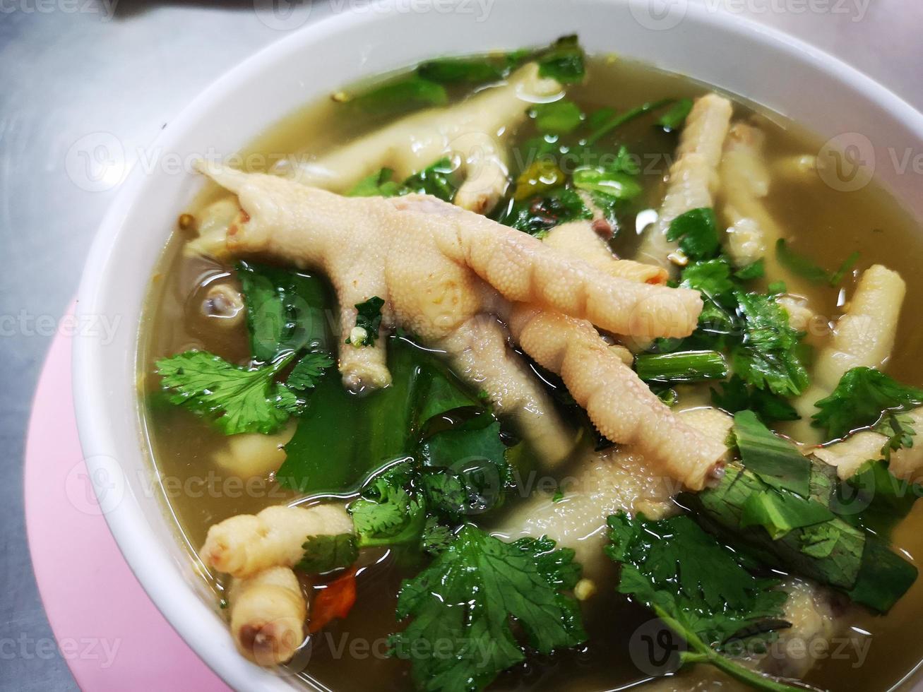 close-up chicken leg in spicy soup with various herbs. Thai food. photo