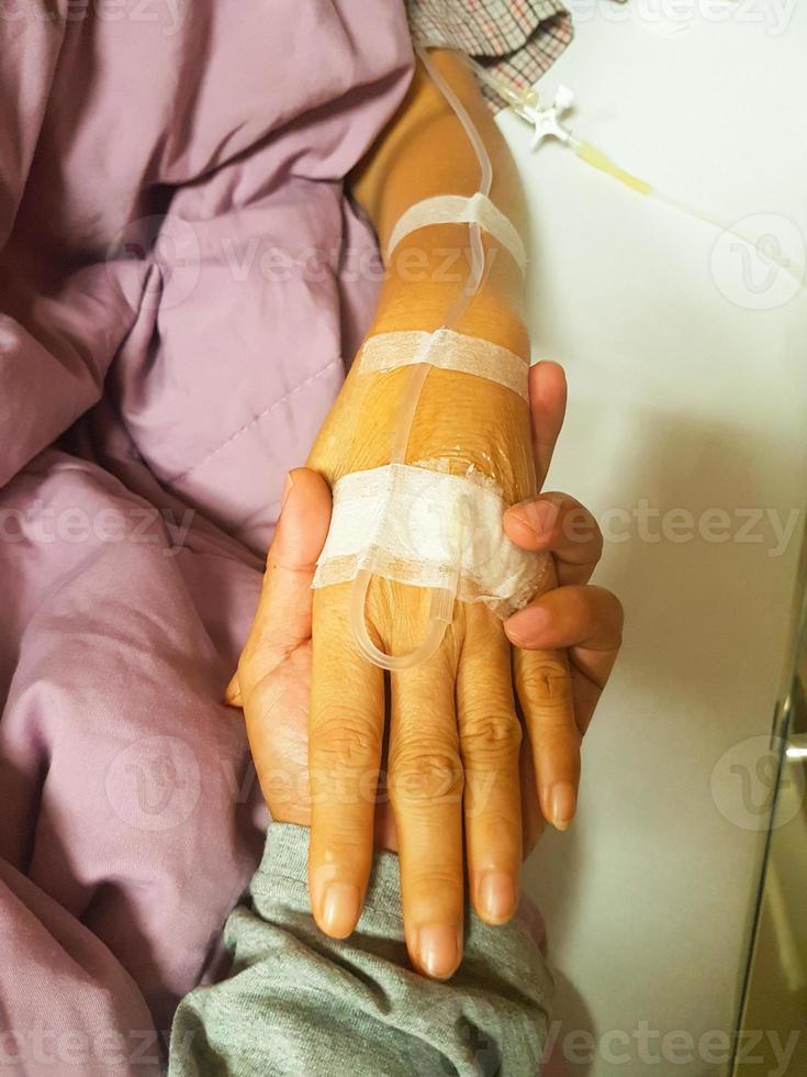 Mano sujetando al paciente con catéter en mano para tratamiento foto