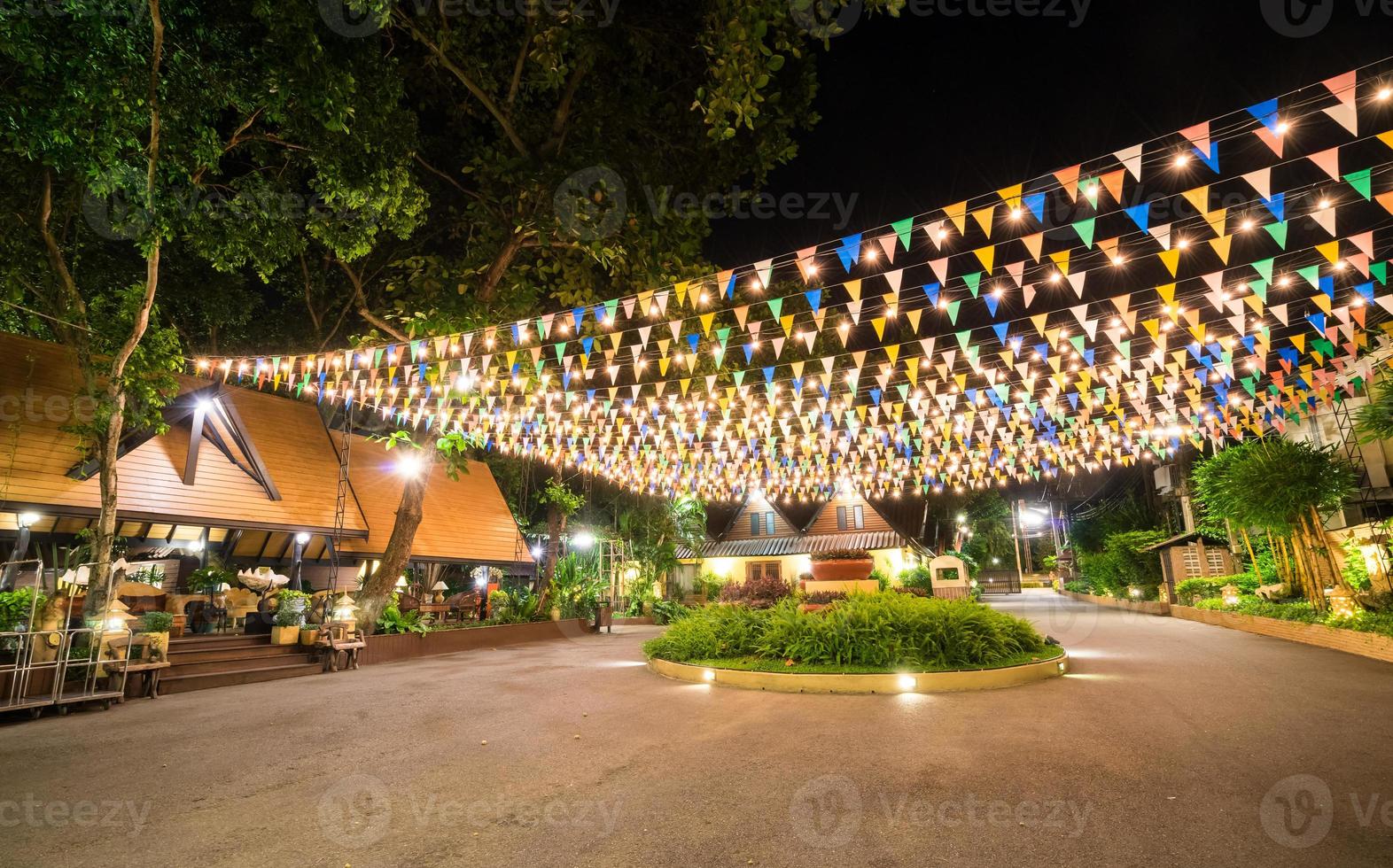 Multi colored triangular Flags Hanging in the sky on outdoor road photo