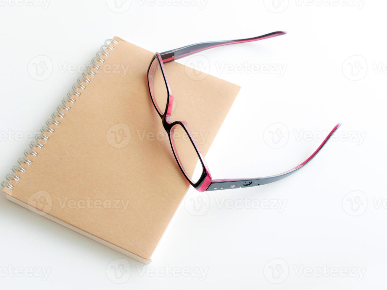 Blank page of a notebook and eyeglasses photo