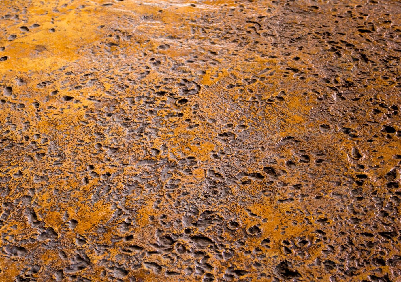 Many rugged holes on the rusty color concrete floor photo