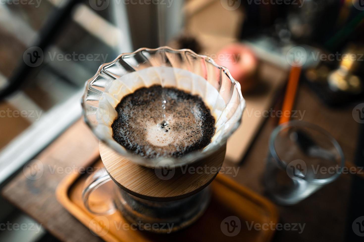 goteo de café en casa, vertiendo agua caliente sobre un goteo de café foto