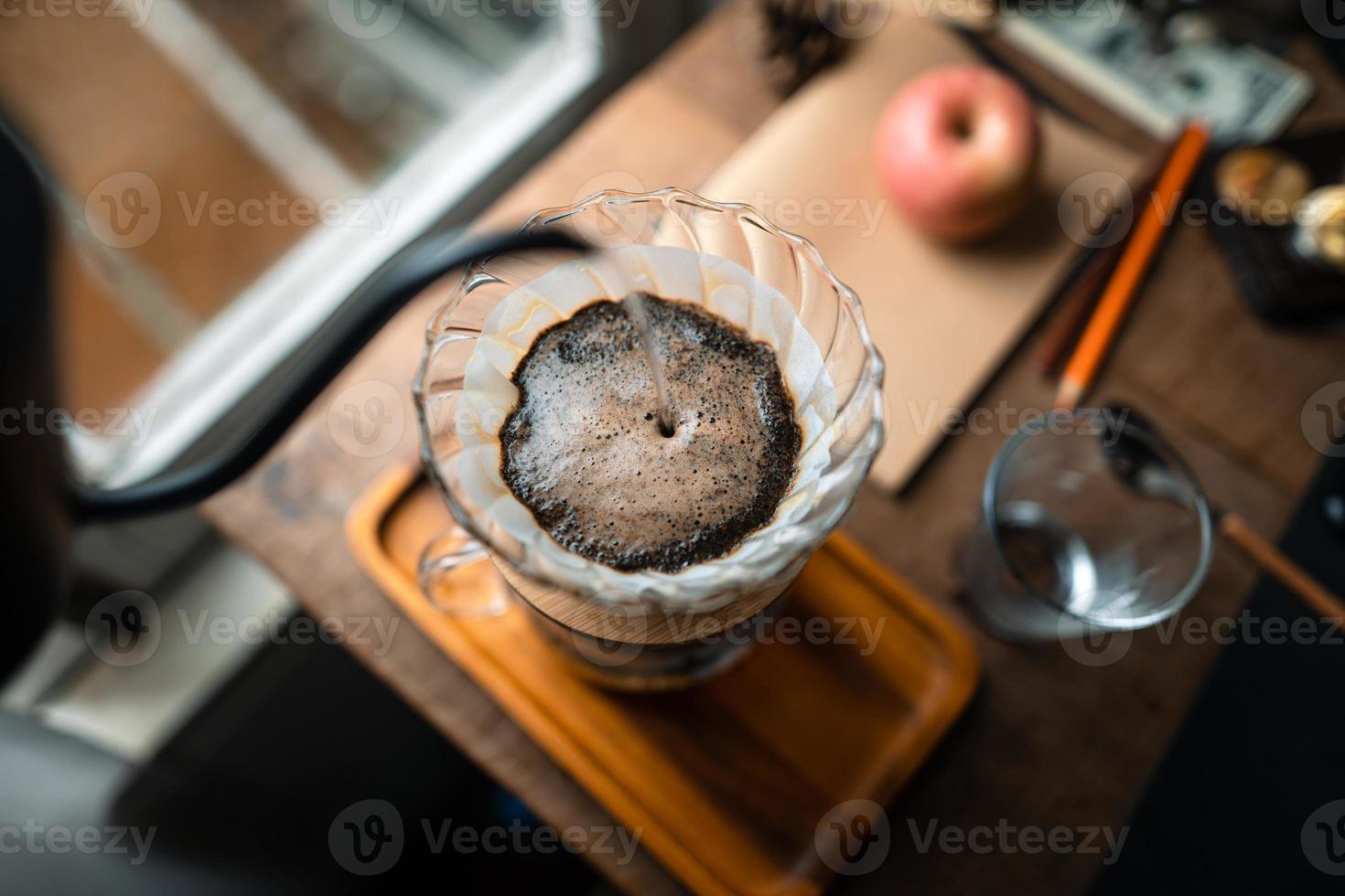 goteo de café en casa, vertiendo agua caliente sobre un goteo de café foto