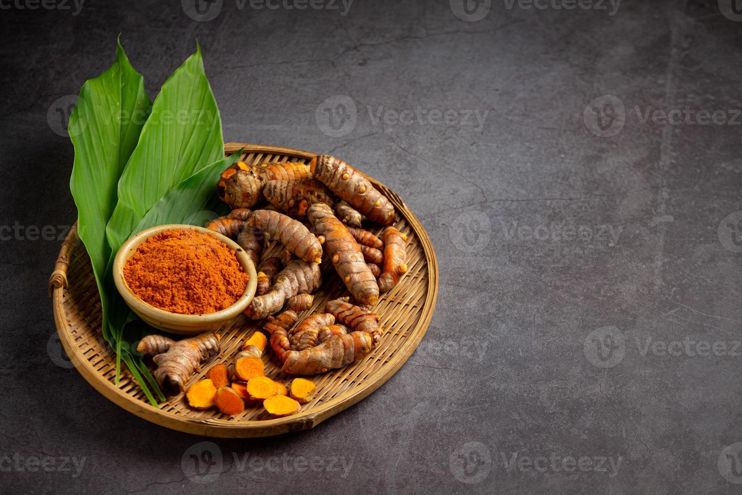 Tumeric rhizome with green leaf and turmeric powder photo