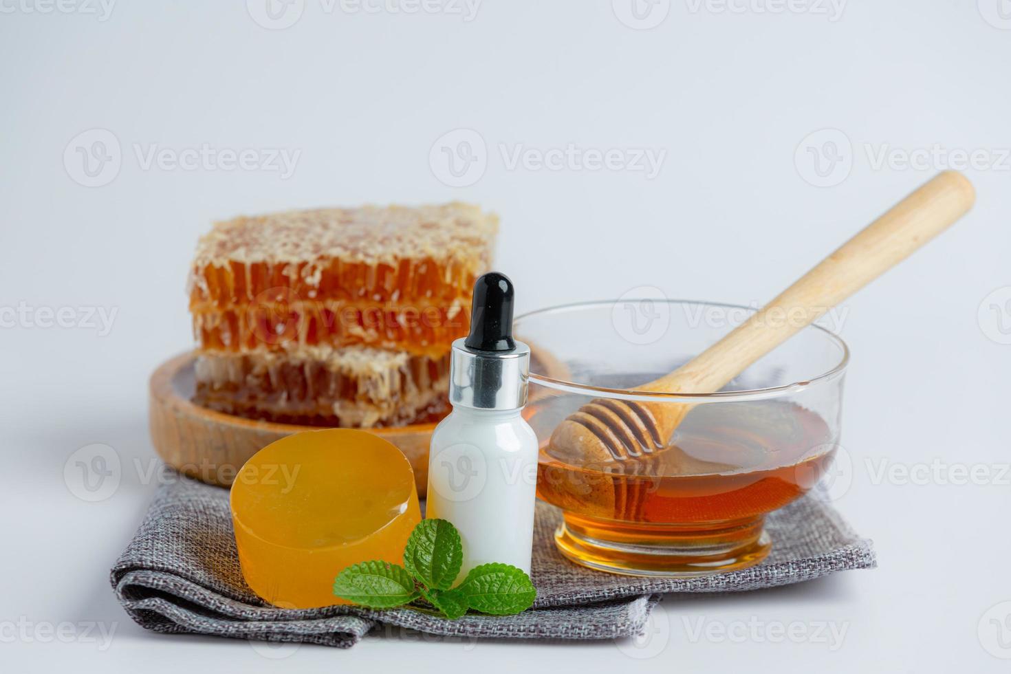 Natural skin care soap and serum with honey and honeycomb laid photo