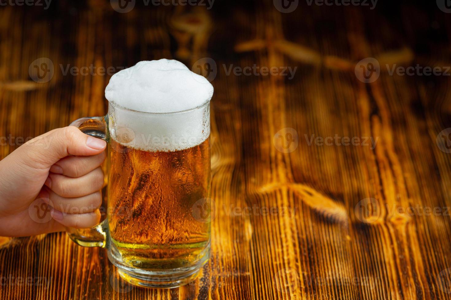 A glass of beer is placed on the wooden floor. photo