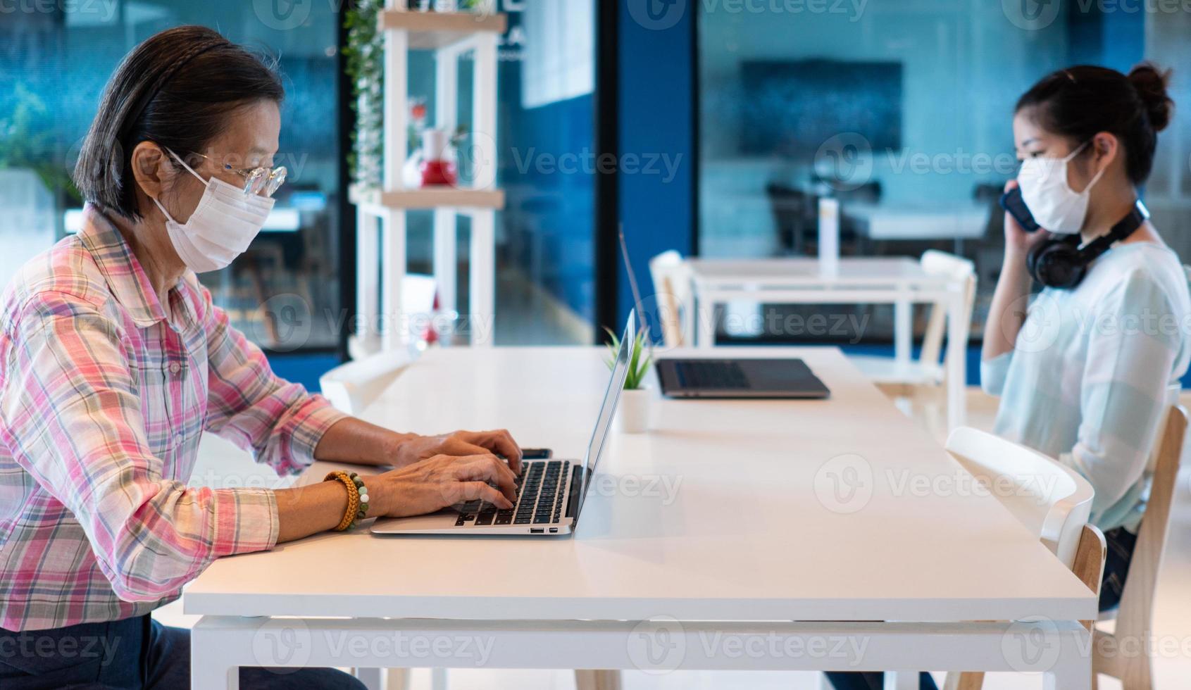 personas que usan máscara y mantienen el distanciamiento social en el espacio de trabajo conjunto foto