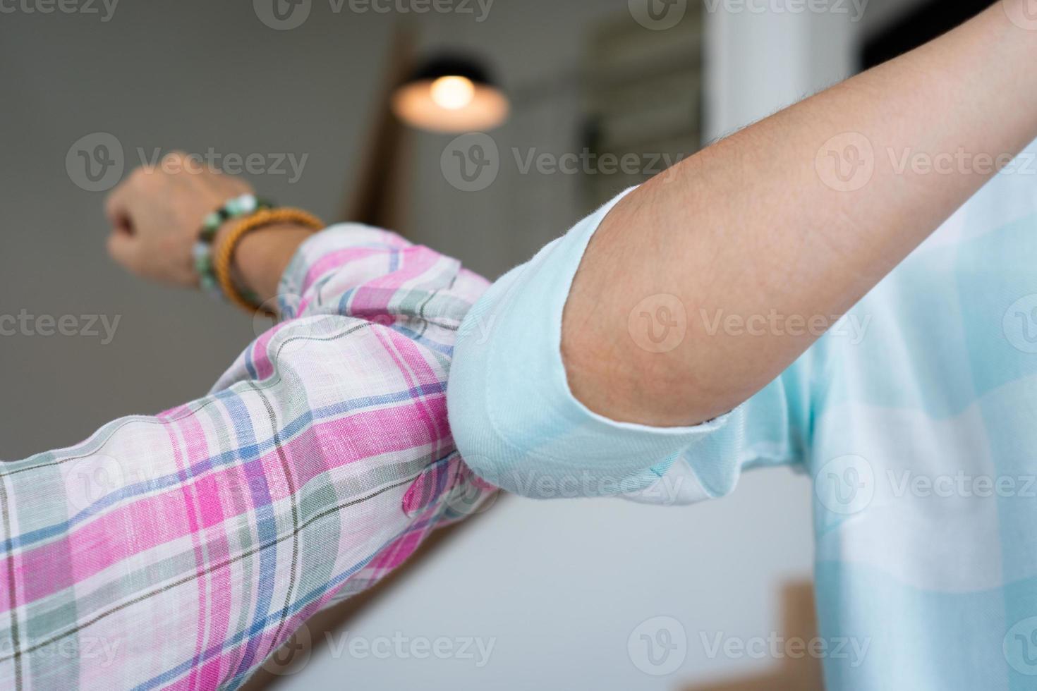 woman making safe greeting by bumping elbow during covid 19 outbreak photo