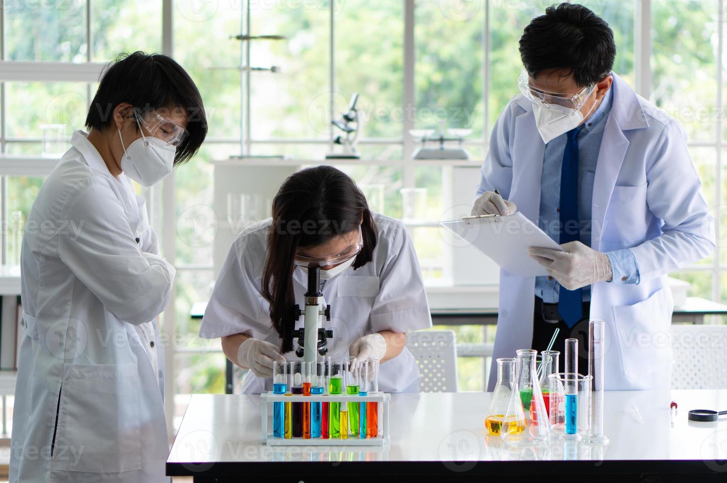 Científico con microscopio para experimentar sobre la vacuna en el laboratorio foto