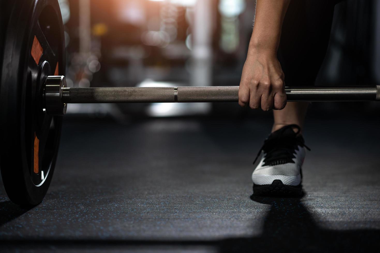 Closeup of young woman holding barbell photo