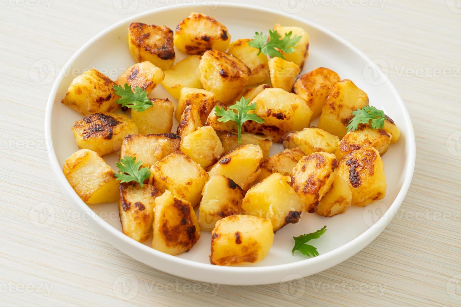 Roasted or grilled potatoes  on plate photo