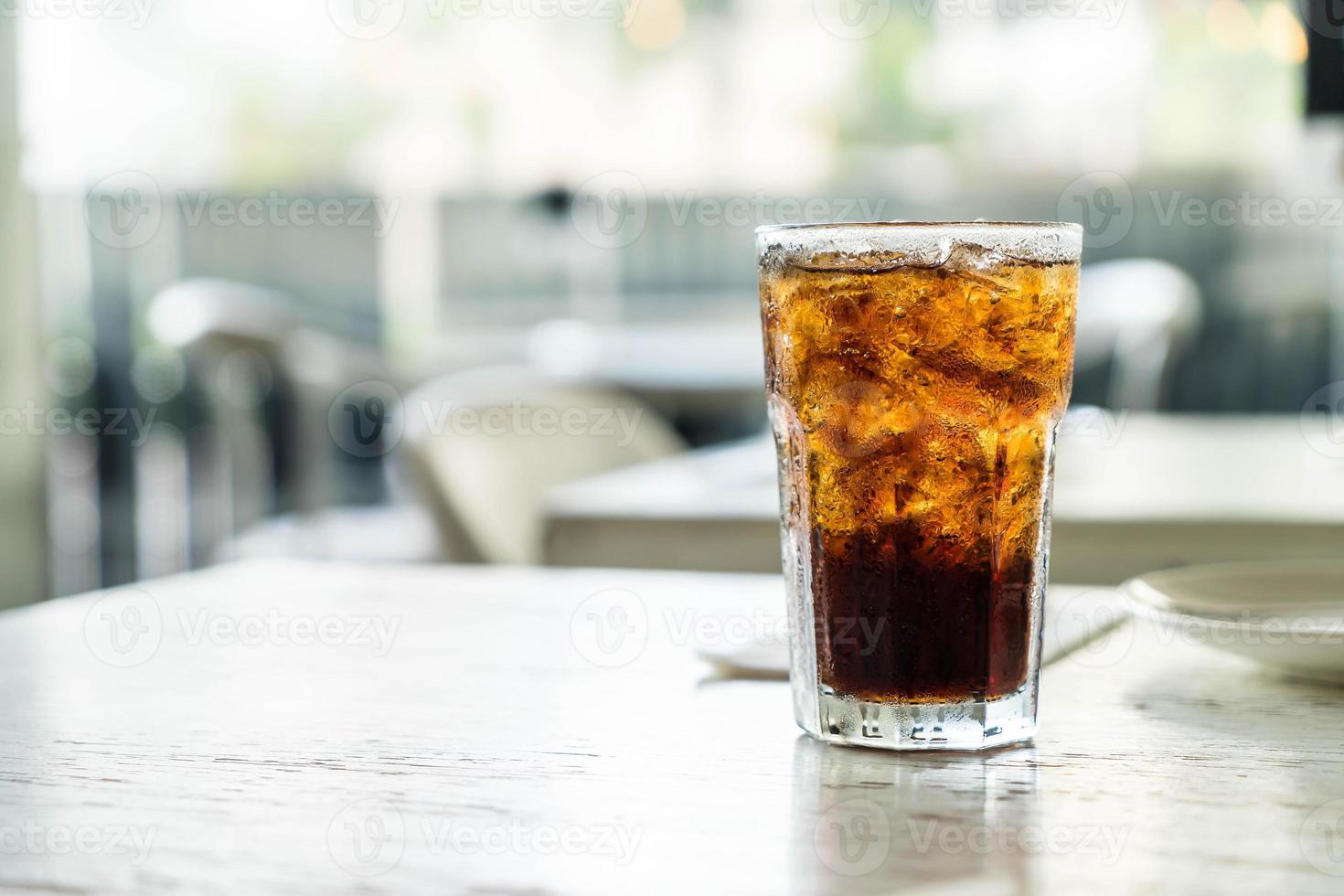 vaso de cola helado en la mesa foto