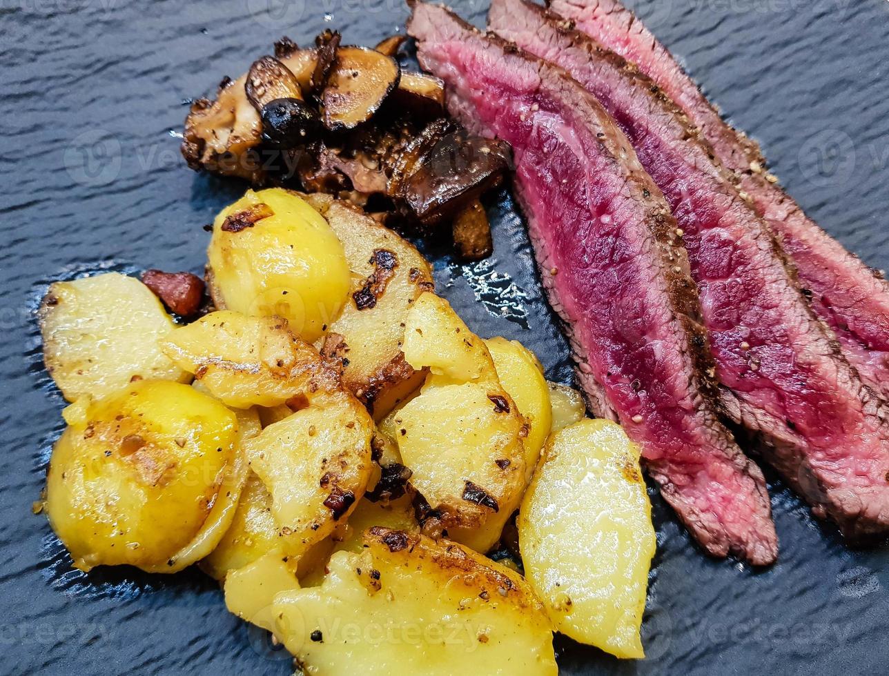 flank steak with forest mushrooms and fried potatoes photo