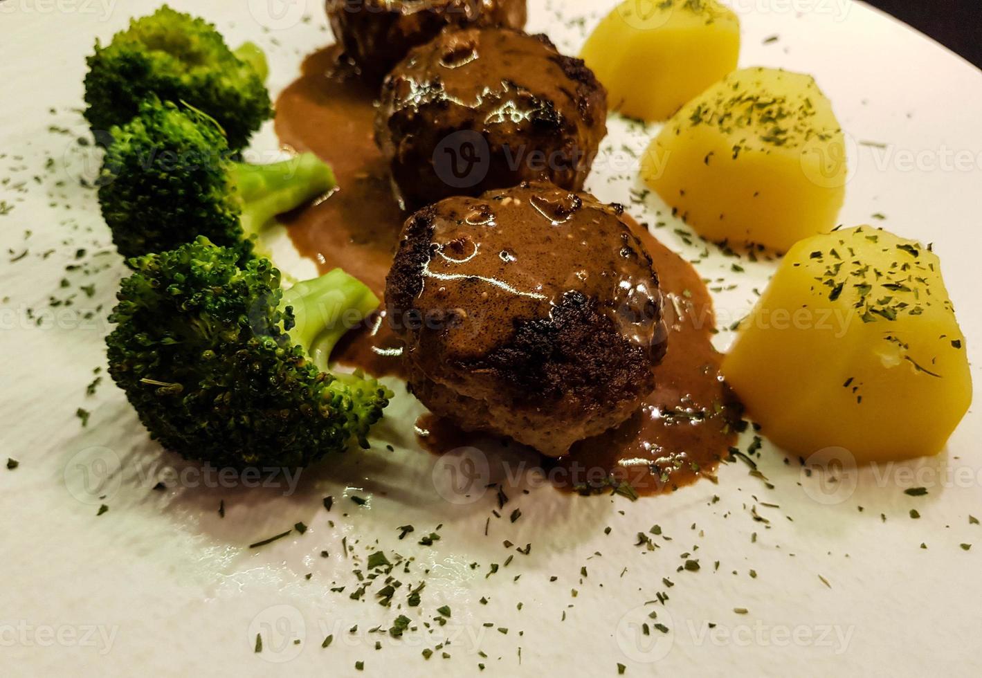 Fried meatballs with boiled broccoli and parsley potatoes photo