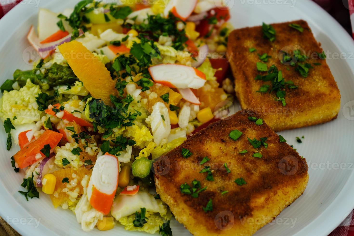 breaded and baked sheep's cheese with surimi salad photo